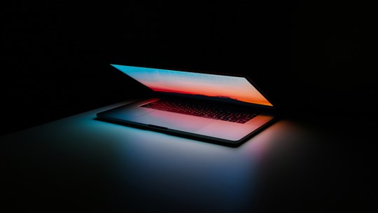 Computerskærm oplyser mørkt rum